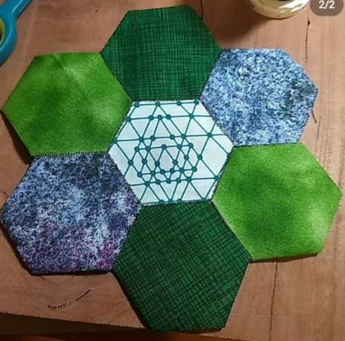 Seven fabric hexagons sewn together in a cluster.